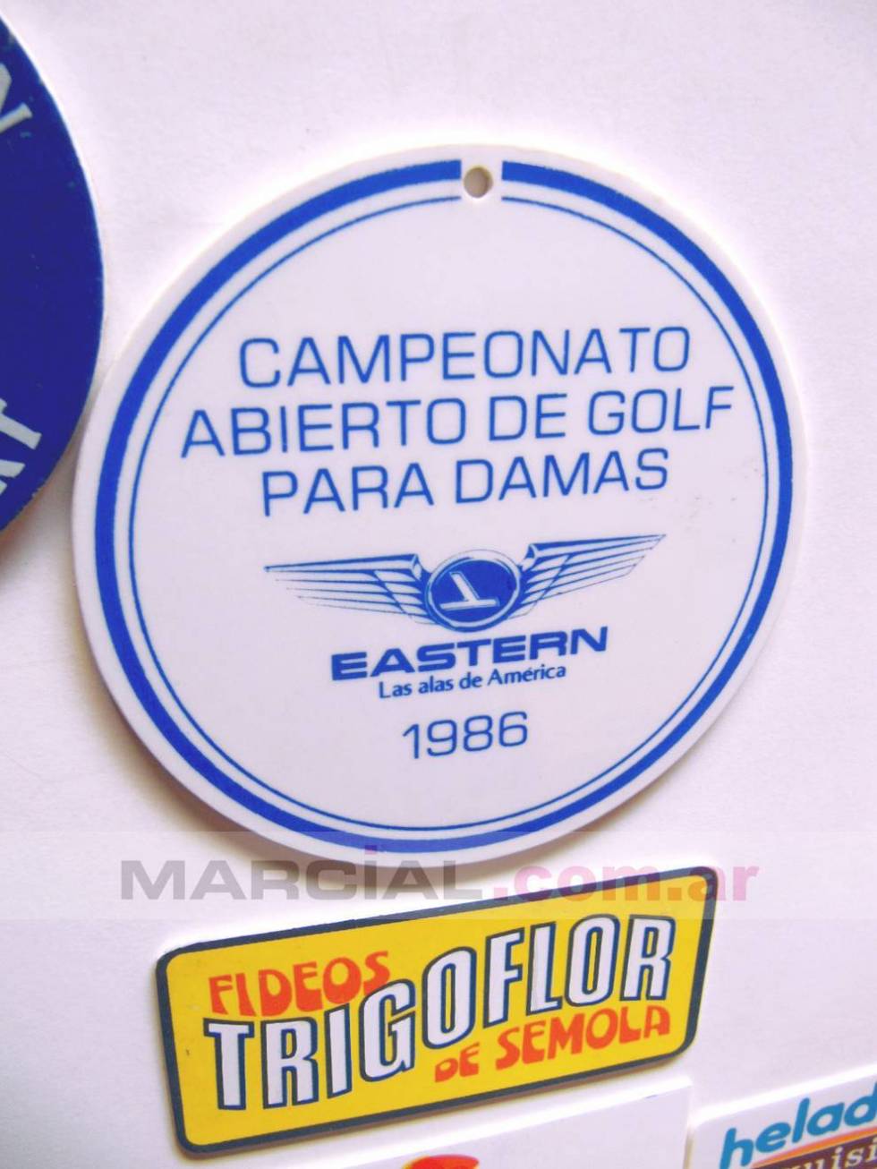 Distintivo impreso en alto impacto y troquelado, impreso   a 1 color en serigrafía. Fue para el Campeonato abierto de Golf para Damas realizado en el año 1986 y auspiciado por la desaparecida aerolínea "Eastern Air Lines". Impreso por Marcial Serigrafía.